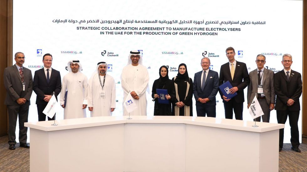 three people signing agreement in United Arab Emirates